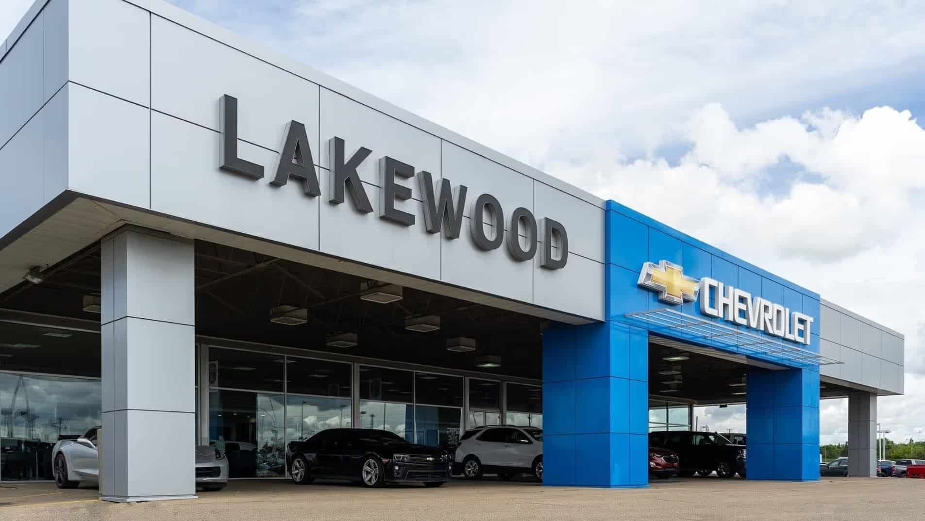 Exterior view of Lakewood Chevrolet dealership featuring large signage, modern architecture, and a selection of vehicles on display.