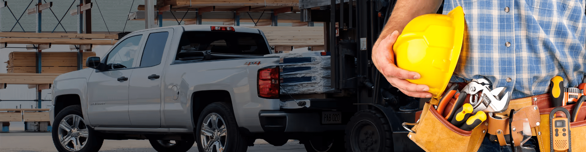Chevrolet and GMC trucks displayed in front of a construction site, emphasizing strength and business capability, with a tagline highlighting a new look for business elite.